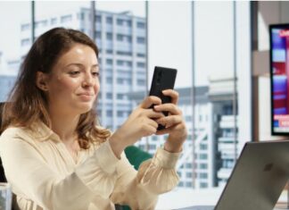 A importância da segurança nos pagamentos digitais mulher no escritório mexendo no celular