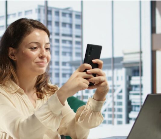 A importância da segurança nos pagamentos digitais mulher no escritório mexendo no celular